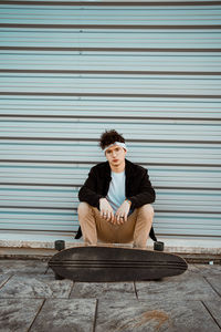 Young man sitting on wall