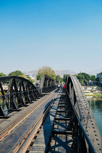Bridge over calm blue sea against clear sky