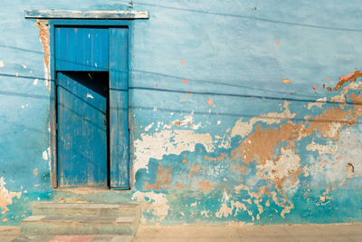 Old weathered blue wall with door