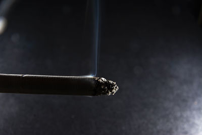Close-up of cigarette against black background