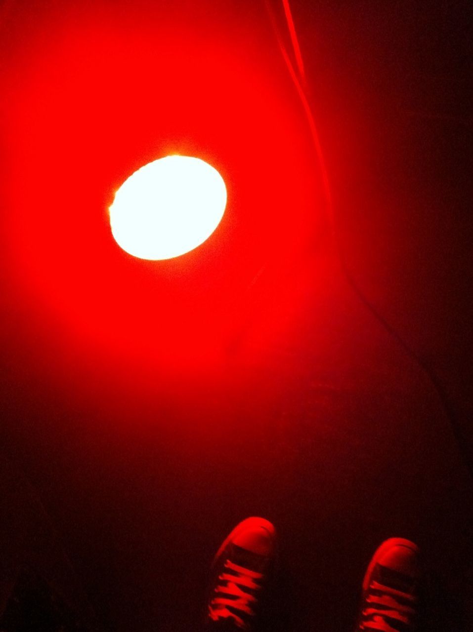 red, indoors, low angle view, copy space, circle, one person, illuminated, dark, close-up, abstract, pattern, part of, studio shot, lighting equipment, night, orange color, geometric shape, light - natural phenomenon, multi colored