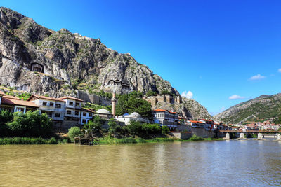 Scenic view of river by buildings in town against clear sky