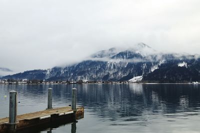 Scenic view of lake by snowcapped mountains against sky