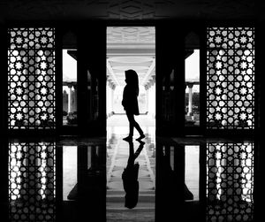 Rear view of silhouette woman walking in corridor of building