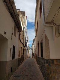 Narrow alley amidst buildings against sky