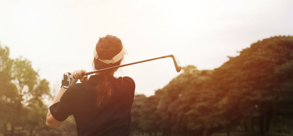 Rear view of person playing against sky