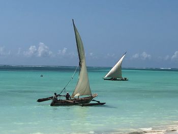 Sailboat in sea against sky