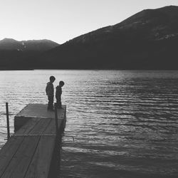 Rear view of two people standing on jetty