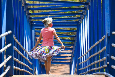 Rear view of woman on footbridge