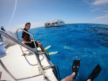 Man photographing ship in sea against sky