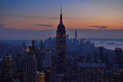 Illuminated buildings against sky during sunset