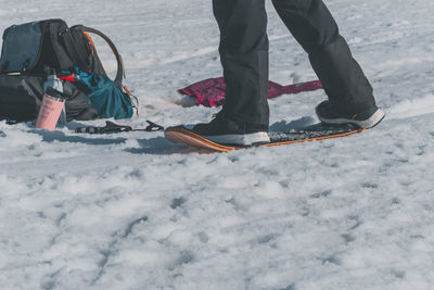 Low section of man skiing on snow covered field