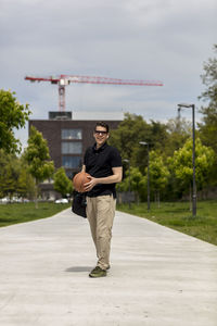 Close-up of mature man throwing basketball while standing outdoors