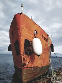 Ship moored on sea against sky