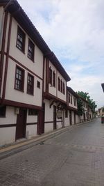 Street amidst buildings in town against sky