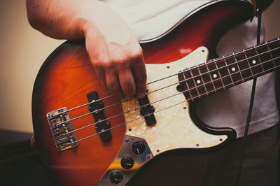 Midsection of guitarist playing electric guitar