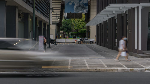 People walking on street amidst buildings in city