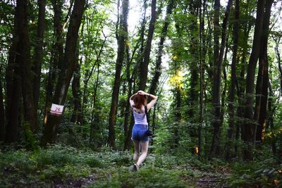 Full length of young woman walking in forest