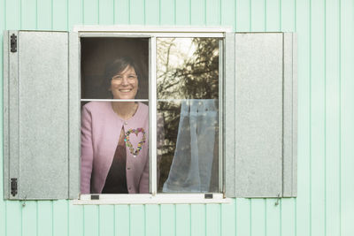 Smiling woman looking through window from trailer