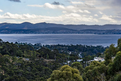 Scenic view of sea by townscape against sky