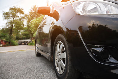 Close-up of black car on road