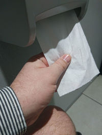 Cropped image of man removing toilet paper