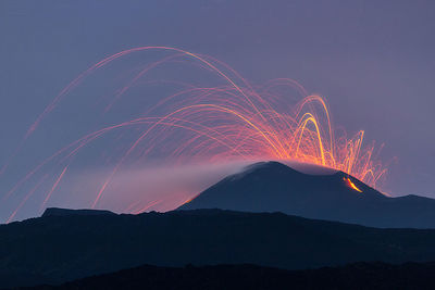 Low angle view of illuminated fireworks against sky at night