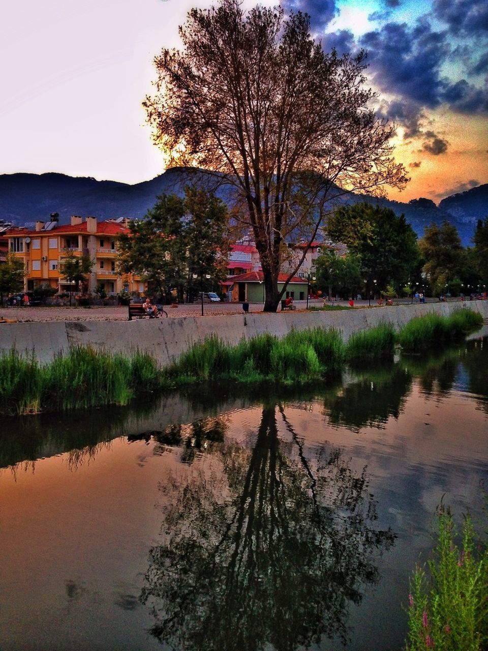 water, tree, building exterior, built structure, architecture, reflection, lake, sky, sunset, river, tranquil scene, bare tree, waterfront, tranquility, house, beauty in nature, nature, scenics, lakeshore, cloud