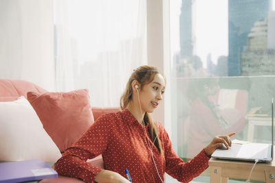 Portrait of woman sitting on sofa at home