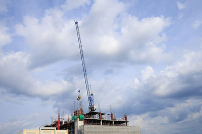 Low angle view of cranes against sky