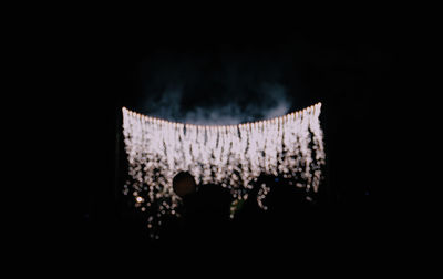 Close-up of christmas lights over black background