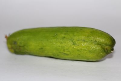 Close-up of green fruit against white background
