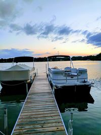 Boats moored on sea against sky during sunset