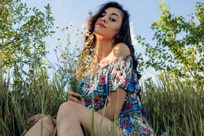 Low angle view of woman sitting against plants