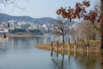 Scenic view of lake by buildings against sky