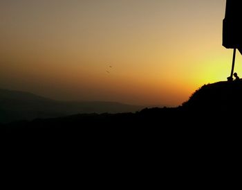 Scenic view of silhouette mountains against sky during sunset