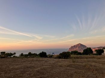 Scenic view of field against sky at sunset