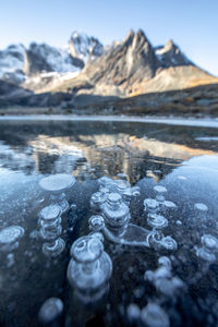 Surface level of frozen lake against mountain