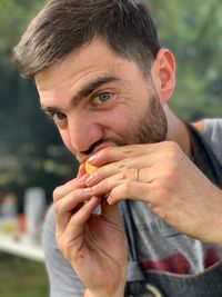 Close-up portrait of man eating fruit