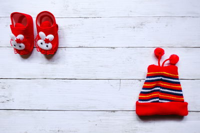 High angle view of baby booties and knit hat on table