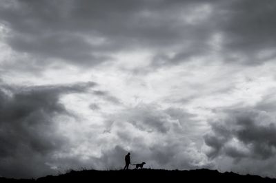 Silhouette man standing against sky