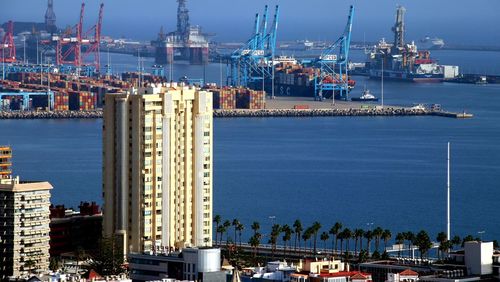 Commercial dock by sea against sky in city