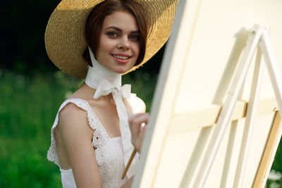 Portrait of young woman wearing hat standing outdoors