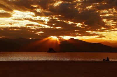 Silhouette of people in sea during sunset