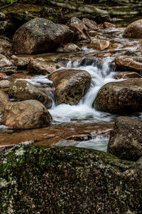 View of stream flowing through rocks