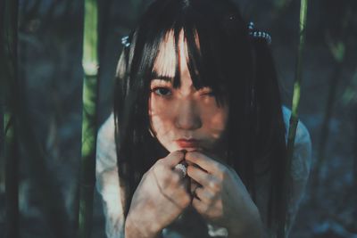 Portrait of young woman by plants