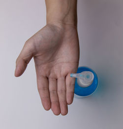 Close-up of hand holding drink over white background