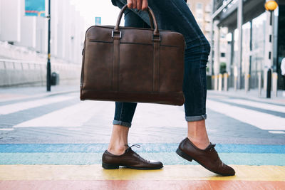 Businessman walking with briefcase on multi colored street