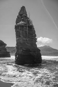Rock formation on sea against sky