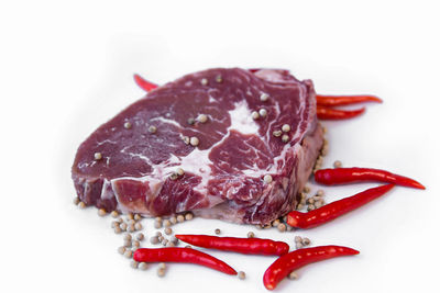 High angle view of red chili peppers on white background